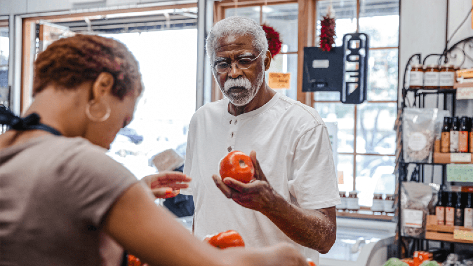 man in market holding a apple