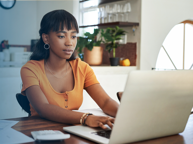 Young woman paying bills on laptop