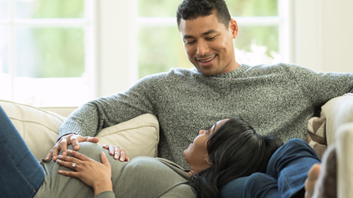 Man and pregnant wife on couch