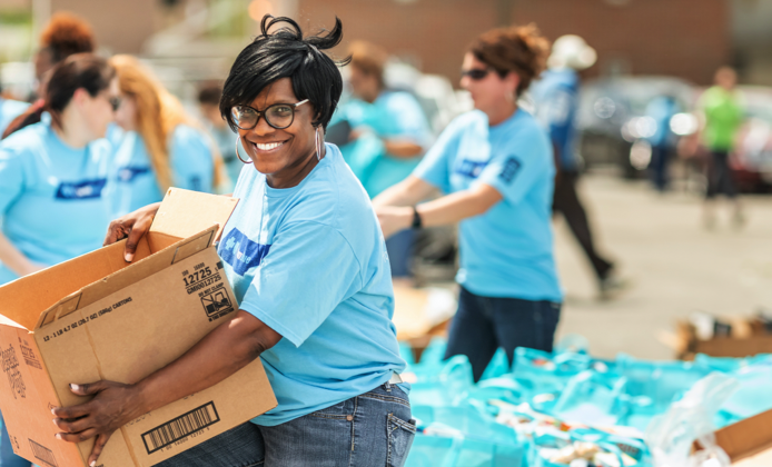 BlueCross BlueShield Team Blue Volunteers stuffing grab bags and passing them out