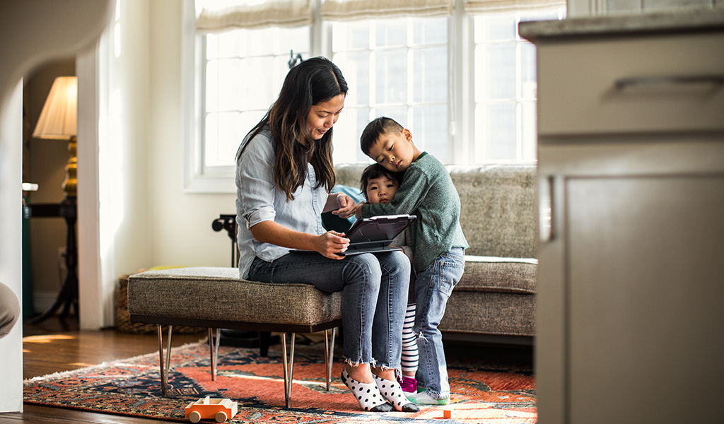 Small family with two kids looking at an iPad together Small family with two kids looking at an iPad together