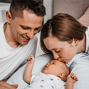Smiling mother and father looking at newborn baby Smiling mother and father looking at newborn baby