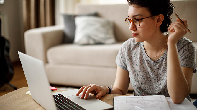 Woman looking up claim summary on her laptop