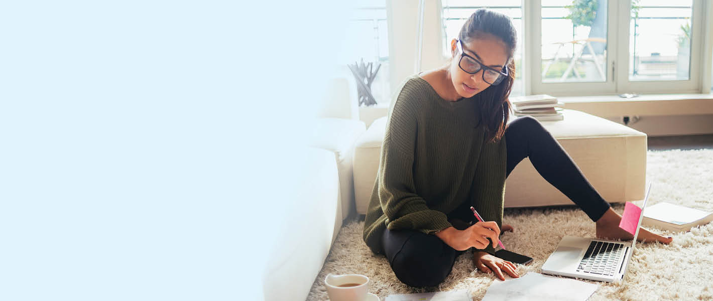 Young woman sitting on floor while working on her computer