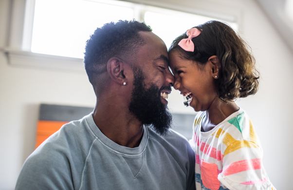 Father and young daughter giggling together