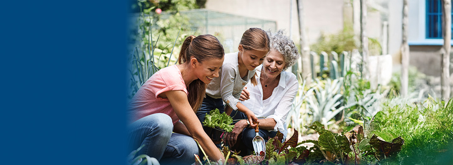 Mom, daughter and grandmother smile while gardening together
