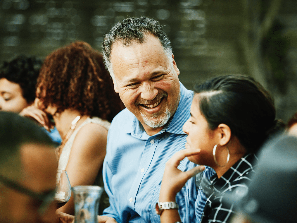 Man drinking wine and laughing with woman