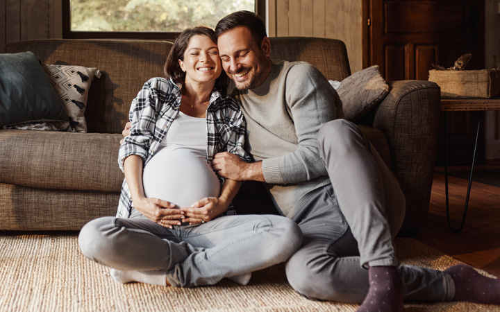 New expecting mother with father in a living room.
