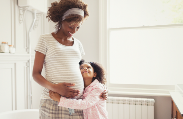 Pregnant mother hugging her young child