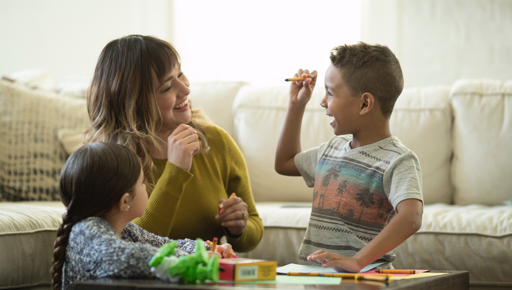 Mother and kids coloring with crayons