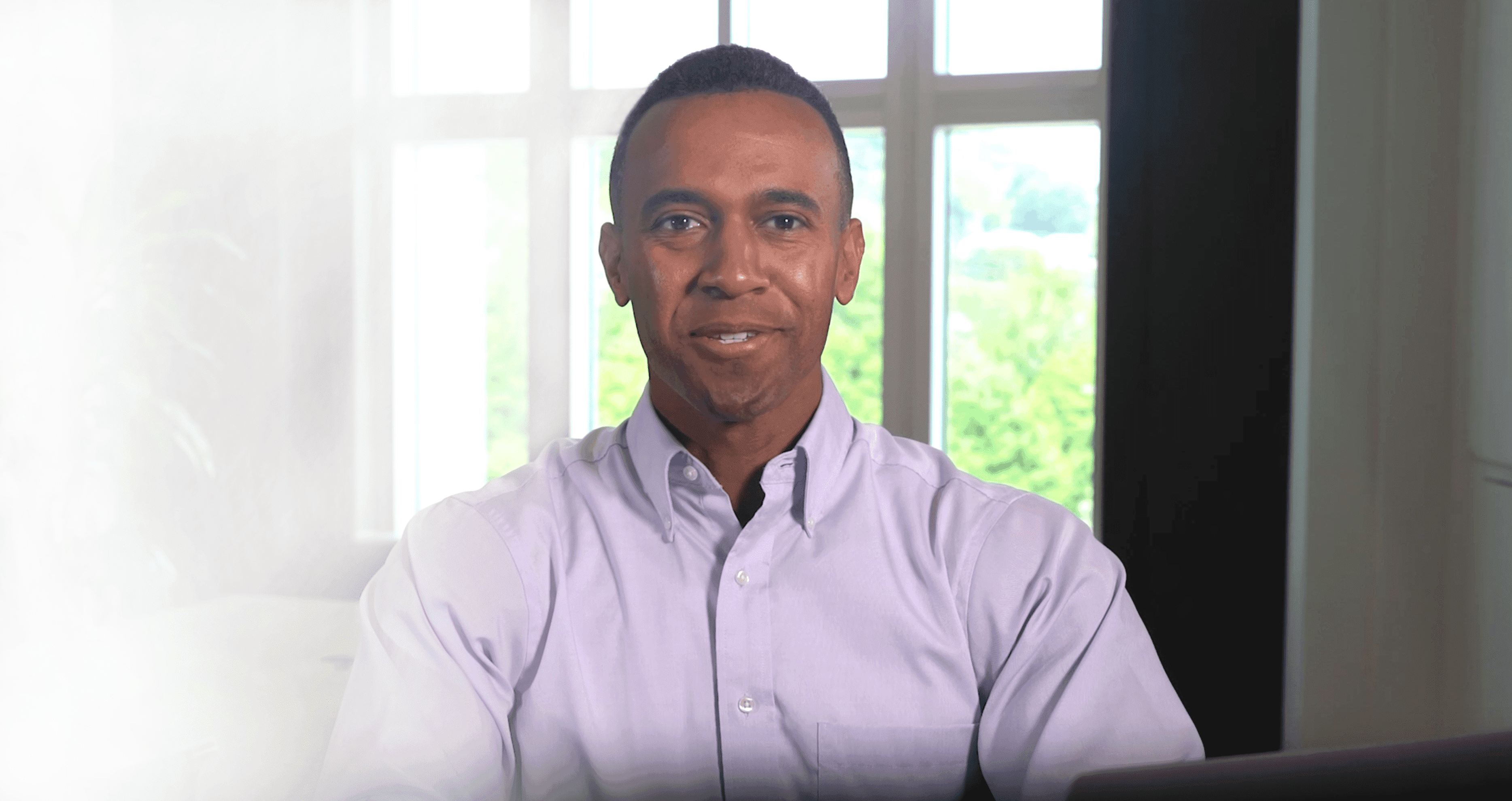 A man sitting at a public table about to talk.
