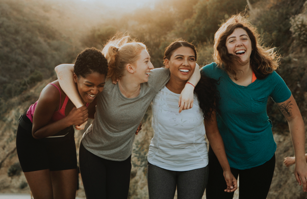 Four female frinds out for a walk outside laughing