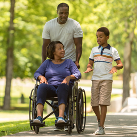 Father and son on walk with grandmother in wheelchair