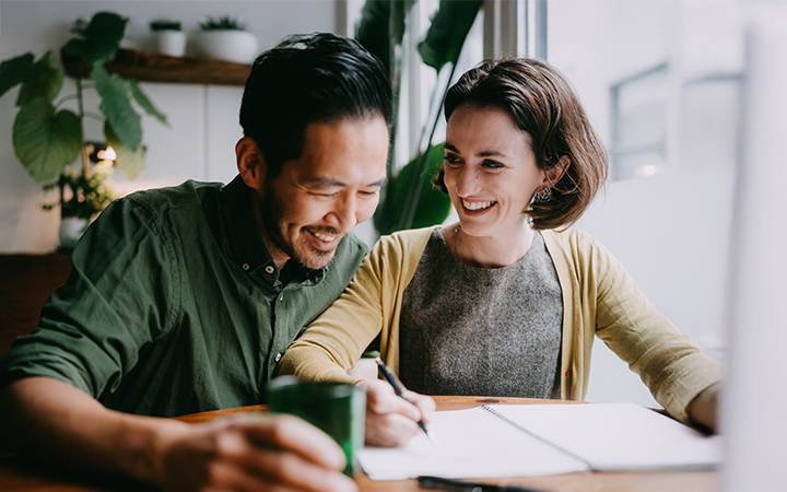 A couple sitting at a table reviewing paperwork.