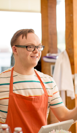 A young man at a grocery store assisting a customer
