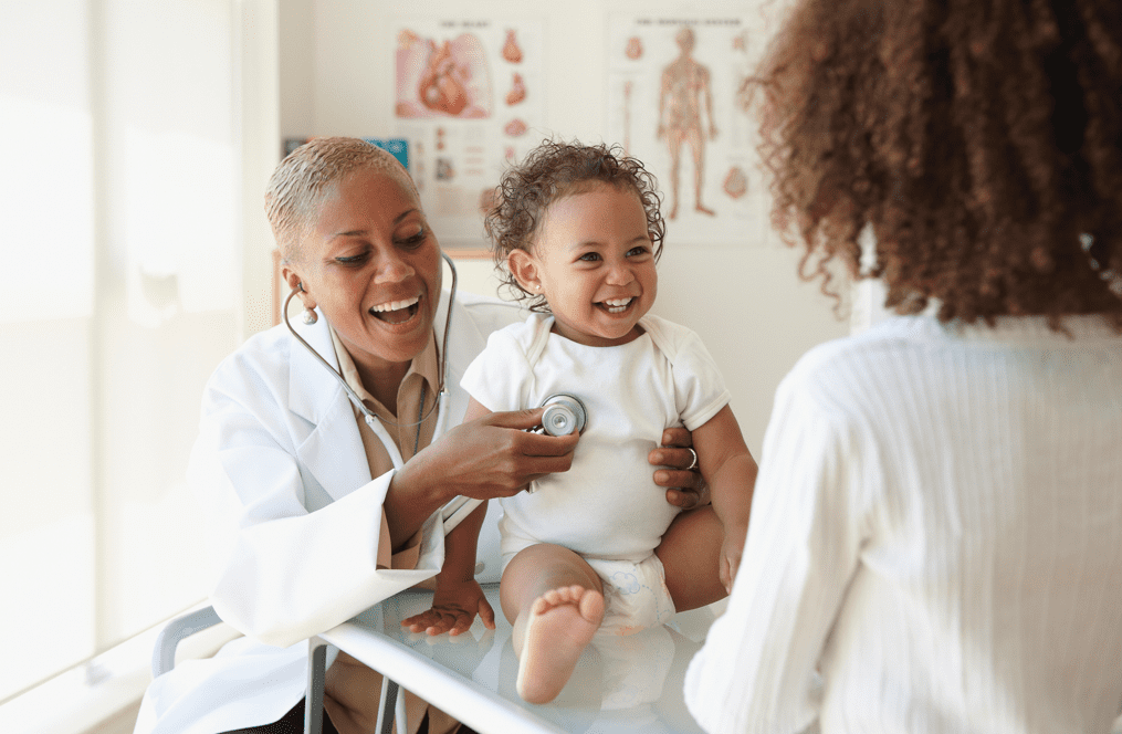 Baby laughing with female doctor and mom Baby laughing with female doctor and mom
