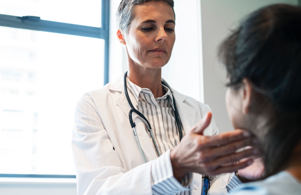 Doctor in white coat checking patient's jaw | BCBS of Tennessee Doctor in white coat checking patient's jaw | BCBS of Tennessee
