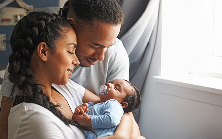 Happy parents smiling lovingly at sleeping baby