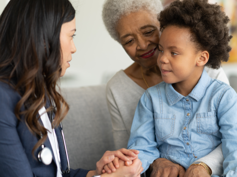 Child sitting in grandmother's lap while talking to doctor | BCBS of Tennessee