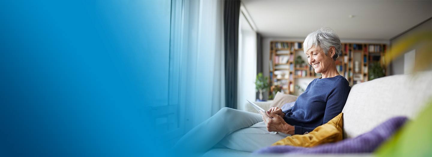A senior woman signing up for home delivery on her tablet.