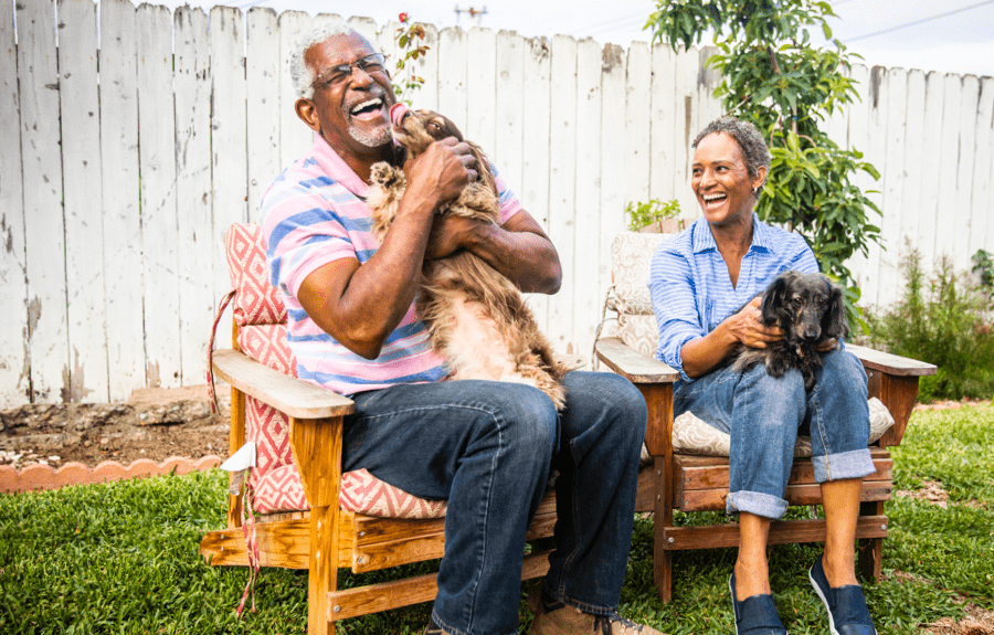 Woman and man holding pets and laughing