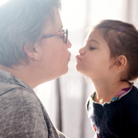 Grandmother giving a kiss to her young granddaughter