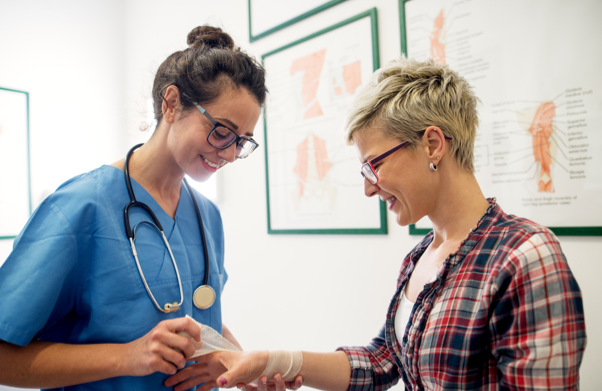 Female doctor with glasses wrapping patient's wrist with bandage | BCBS of Tennessee